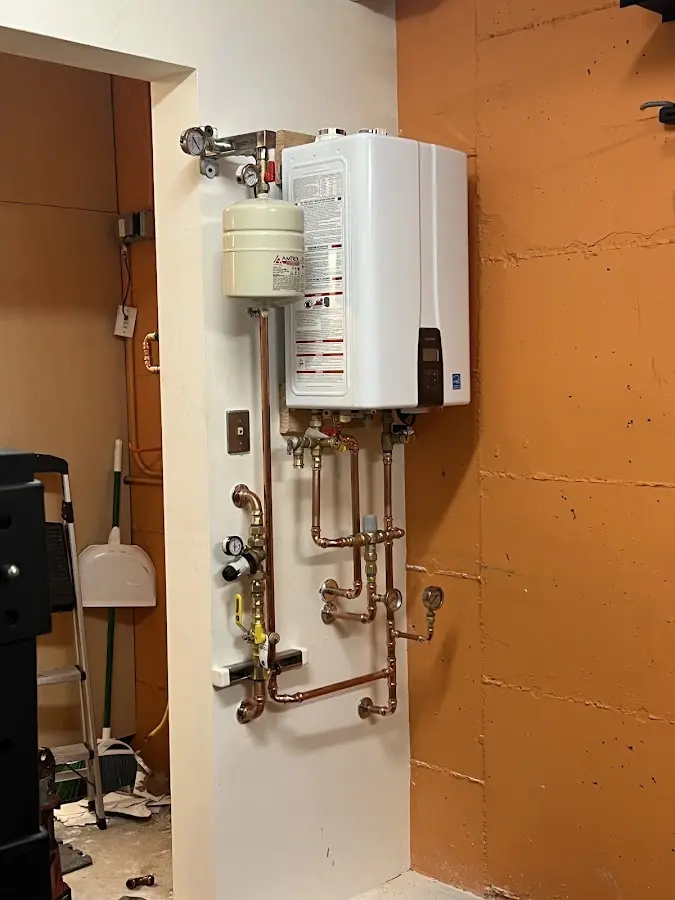 Plumbing technician inspecting water heater connections in Pleasanton